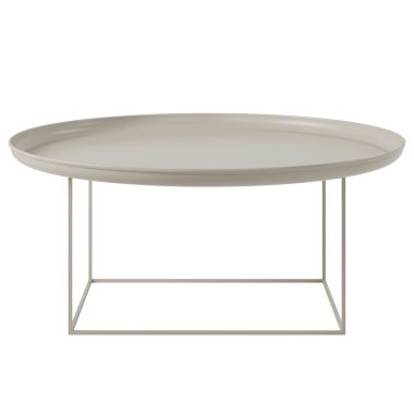 En minimalistisk beige oval NORR11 - Duke Sofabord Ø90 med en glat bordplade og en tynd, geometrisk metalbund, isoleret på en hvid baggrund.