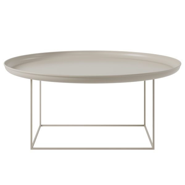 En minimalistisk beige oval NORR11 - Duke Sofabord Ø90 med en glat bordplade og en tynd, geometrisk metalbund, isoleret på en hvid baggrund.