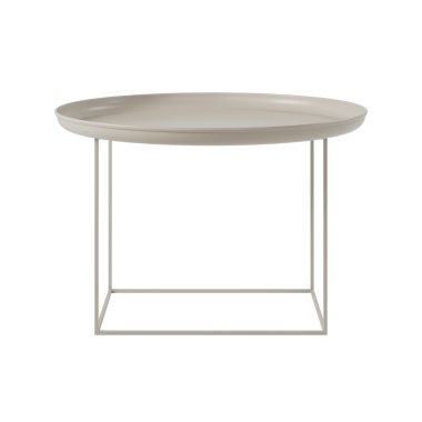 En minimalistisk moderne NORR11 - Duke Sofabord Ø70 med en rund beige top og en tynd firkantet hvid metalramme, isoleret på en hvid baggrund.