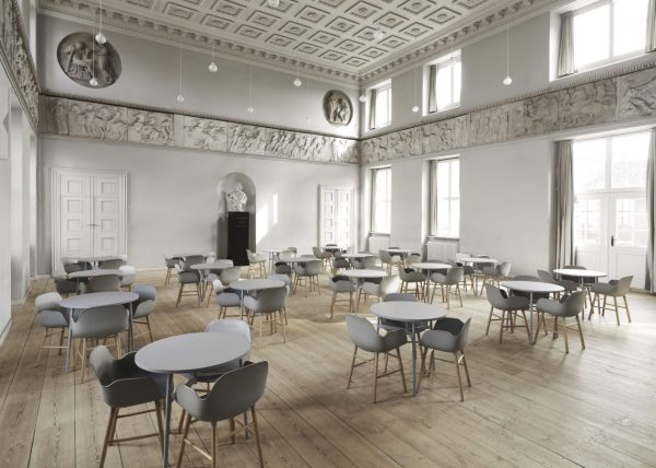 Stort, elegant designet værelse med trægulve og højt til loftet, med udsmykkede hvide lister og flere buster langs væggene. Talrige designmøbler i grå og blå er pænt arrangeret overalt.