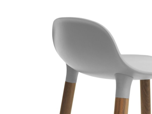 Nærbillede af en NORMANN COPENHAGEN - Form Barstol 65 med et glat, matgrå sæde og træben, isoleret på en hvid baggrund.
