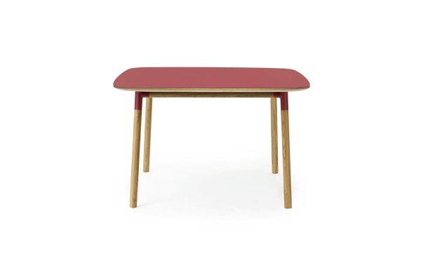 Et moderne bord med en rektangulær, mørkerød plade og fire træben fra TomorrowsDesign, isoleret på en hvid baggrund.