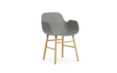 En moderne grå lænestol med træben, isoleret på en hvid baggrund. Stolen har et glat, buet design med støttende armlæn og repræsenterer essensen af moderne designmøbler.