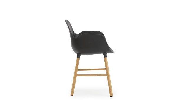En moderne design barstol med sort plastiksæde og træben, set fra en sidevinkel, isoleret på en hvid baggrund.