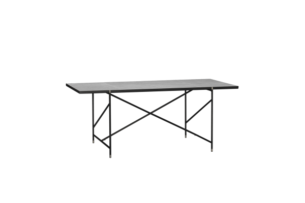 Et rektangulært bord med marmorplade og sort metalstel, sat mod en almindelig grøn baggrund.