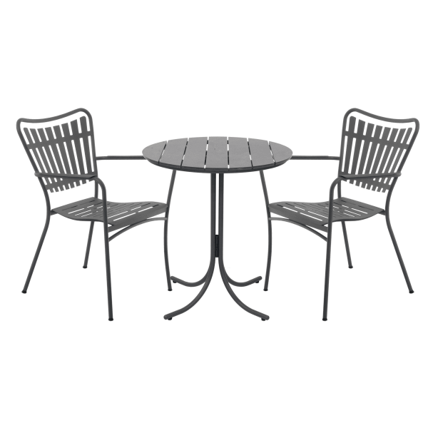 To grå metalstole med buede ryglæn vendt mod hinanden, placeret omkring et lille, rundt metalbord fra TomorrowsDesign, alle sat mod en almindelig grøn baggrund.
