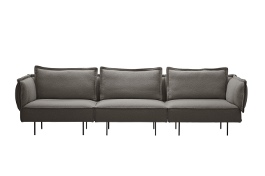 En moderne grå sektionssofa med plyshynder og tynde sorte ben, designet af TomorrowsDesign, sat mod en solid grøn baggrund.