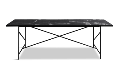 Et sort metal skrivebord med en rektangulær top og en x-ramme støttestruktur. Skrivebordet har en hylde lige over gulvet til ekstra opbevaring. Billedet er sat mod en solid grøn baggrund. Dette stykke er en del af TomorrowsDesign-kollektionen.
