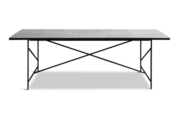 Et rektangulært bord med marmorplade med en sort metalbund med en x-formet ramme og en nederste hylde. Bordet er sat mod en solid grøn baggrund og viser dets innovative TomorrowsDesign.