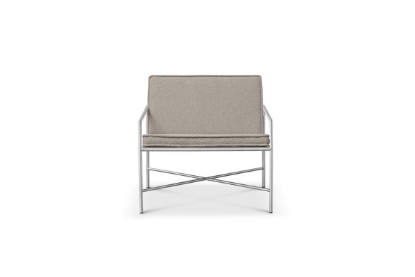 En moderne stol med et slankt, krom stel og lyse beige hynder, set forfra på en almindelig hvid baggrund, er indbegrebet af moderne interiørdesign.