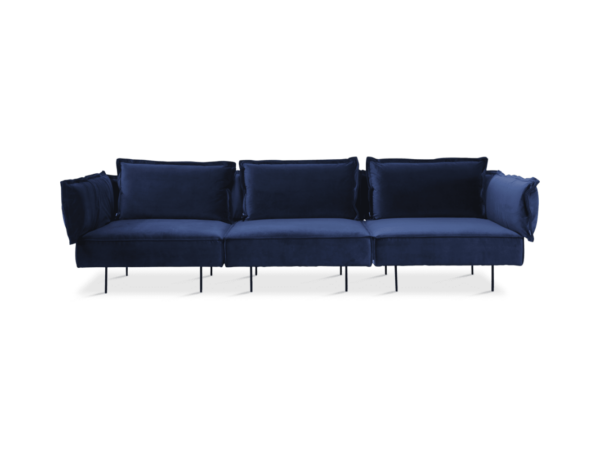 En luksuriøs marineblå fløjlssofa med seks sædehynder og ekstra pudepuder, alle sat på tynde metalben, isoleret på en mørk baggrund. Dette stykke eksemplificerer elite designmøbler.