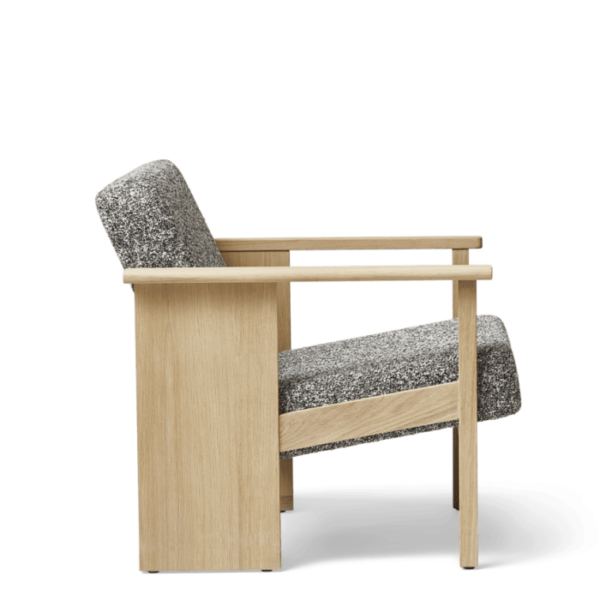 En moderne lænestol med en lys træramme og tekstureret gråt polstring, isoleret på en sort baggrund. Stolens interiørdesign har rene linjer og en minimalistisk stil.