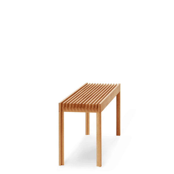 En simpel FORM & REFINE - Letvægts Bænk med parallelle lameller på toppen, stående på en solid grøn baggrund, en del af TomorrowsDesign-kollektionen. Bordet kaster en mørk skygge til højre, hvilket indikerer en lyskilde til venstre.