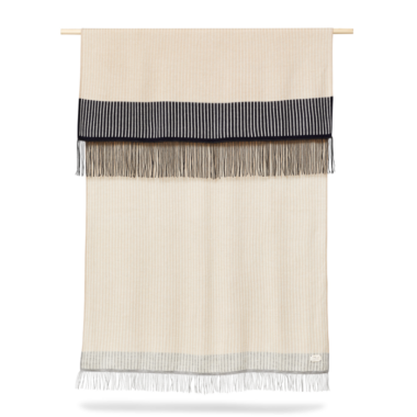 A FORM & REFINE - Aymara Plaid Stripes 190x130 vægophæng med en cremefarvet base med vandrette sorte og grå striber øverst og nederst, suppleret med frynsede kanter, vist på en træstang.
