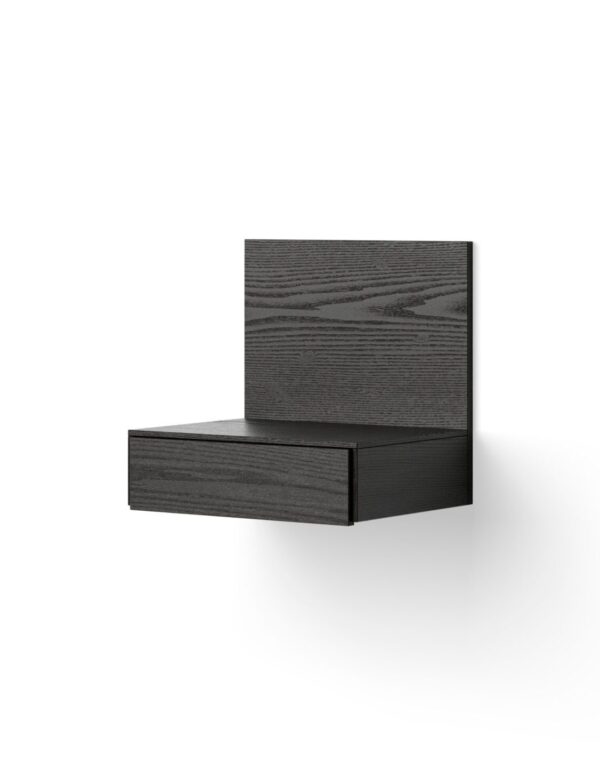 To lukkede sorte bøger med teksturerede omslag, stablet i en l-form, mod en almindelig hvid baggrund.