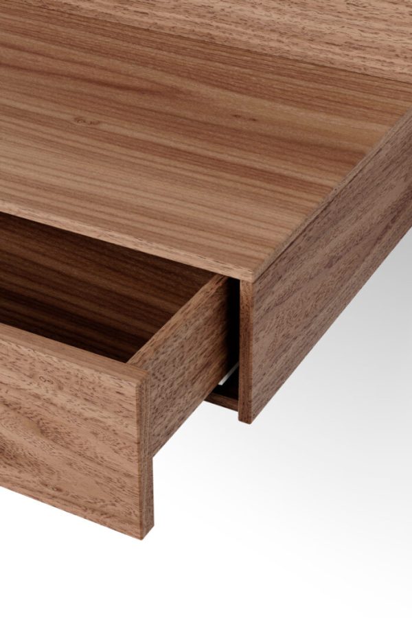 Nærbillede af et NYT VÆRK - Tana Væghængt Natbord, der viser en delvis åben skuffe med synlige træårer, der illustrerer produktets design og finish.