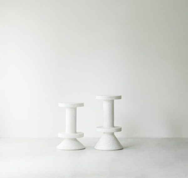 To NORMANN COPENHAGEN - Bit Barstol 75 taburetter i varierende højde, med cylindriske sæder og koniske baser, sat mod en almindelig lysegrå baggrund.