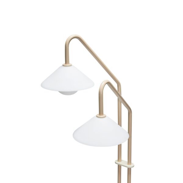 En moderne gulvlampe med to hvide skærme og en messingfinish, med et elegant buet design. lampen er sat mod en almindelig hvid baggrund.