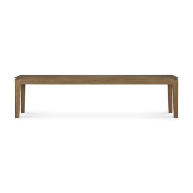 En Bok bænk - teaktræ med fire lige ben. Bænken har et enkelt, minimalistisk design med en glat overflade og naturlig træfinish. Baggrunden er ensfarvet hvid.