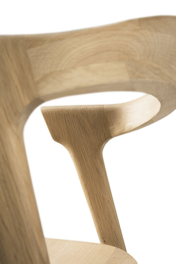 Nærbillede af en del af en Bok spisestol - eg, med fokus på ryglæn og støttestruktur. Træet har en glat, let finish med synlige åremønstre, der viser stolens moderne, minimalistiske design.