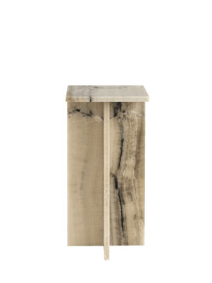 EN WABI SABI NORDIC - Honning Piedestal lavet af poleret træ med naturlige åremønstre, mod en grøn baggrund. Bordet har en glat, flad plade og en buet, skulpturel base.